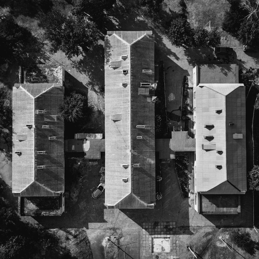 Black-and-white aerial view of the roofs of 3 homes